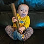 Corsen is registered to the contest to win money with this photo: baby, pacifier, hammer, yellow_shirt, striped_pants, blue_eyes, leather_couch, sitting, indoor, child, footwear, toy, expression, holding, furniture, young_child, cute, person, blue_socks, casual_clothing