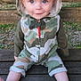baby, child, hoodie, camouflage, bench, outdoor, grass, smile, face, blue_eyes, sitting, wood, clothing, cute, portrait, legs, barefoot, young, person, nature