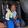 baby, blanket, blue_shorts, car_interior, car_seat, child, cute, hair_puffs, hand, infant, joyful, person, playful, safety, seatbelt, sitting, smiling, sneakers, toddler, white_shirt