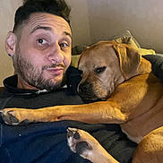 Fox participe au concours pour gagner de l'argent avec cette photo : man, dog, couch, indoor, smile, pet, friendship, cozy, relaxing, brown_dog, casual_clothing, face, paw, living_room, human, animal, portrait, comfort, expression, home
