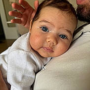 Sidra a rejoint le concours — aidez-le/la à gagner de superbes lots ! baby, infant, blue_eyes, face, close_up, adult, beard, hand, white_clothing, curious, skin, portrait, indoor, holding, shoulder, cute, expression, human, parent, child
