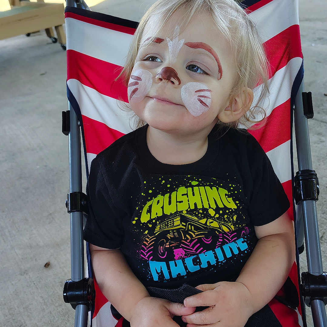 Noah joined the competition — help win amazing prizes! black_clothing, blond_hair, casual, child, concrete_floor, cute, daylight, face_paint, happy, outdoor, people, portrait, red, shorts, sitting, smiling, striped, stroller, toddler, white