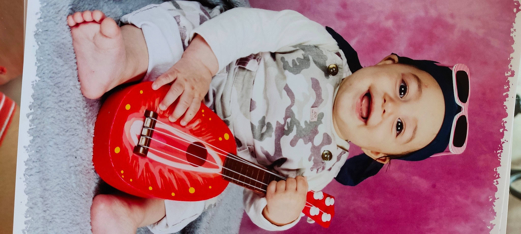 Alana Gabrielle a rejoint le concours — aidez-le/la à gagner de superbes lots ! baby, baby_laughing, baby_toddler_clothing, guitar, guitar_accessory, hand, happy, headwear, mouth, music, musical_instrument, person, photograph, pink, plant, plucked_string_instruments, smile, string_instrument, string_instrument_accessory, toddler