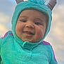Jahmir is registered to the contest to win money with this photo: baby, child, costume, monster, smile, happy, face, outdoor, sky, blue, purple, fuzzy, hood, horns, person, cute, portrait, hand, funny, expression