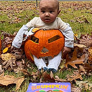 Jahmir joined the competition — help win amazing prizes! baby, pumpkin, carved_pumpkin, autumn_leaves, grass, book, fall, outdoor, child, costume, cute, face, expression, holiday, seasonal, nature, sitting, orange, smiling, leaf