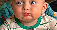 Myles joined the competition — help win amazing prizes! baby, child, face, blue_eyes, puckered_lips, striped_shirt, green_trim, baby_seat, colorful, orange, blue, toy, indoor, portrait, cute, infant, expression, curious, closeup, skin