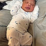 Kashton is registered to the contest to win money with this photo: newborn, baby, sleeping, pajamas, dinosaur_print, infant, cozy, bed, blanket, soft, cute, child, resting, indoors, clothing, person, peaceful, small, human, lying_down
