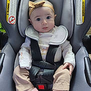 Jaliah is registered to the contest to win money with this photo: baby, infant, car_seat, headband, straps, pink_socks, clothing, seat_belt, child, cute, portrait, indoors, sitting, car_seat_warning, baby_girl, face, eyes, hands, footwear, safety