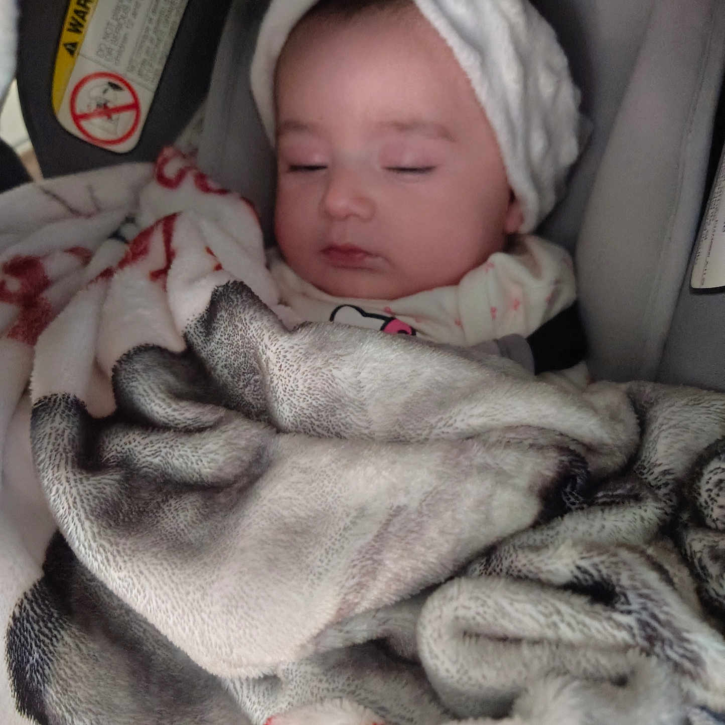 Jaliah is registered to the contest to win money with this photo: baby, blanket, bow, car_seat, child, closed_eyes, clothing, comfort, cozy, cute, face, headband, indoor, infant, portrait, resting, sleeping, soft, warning_label, wrapped