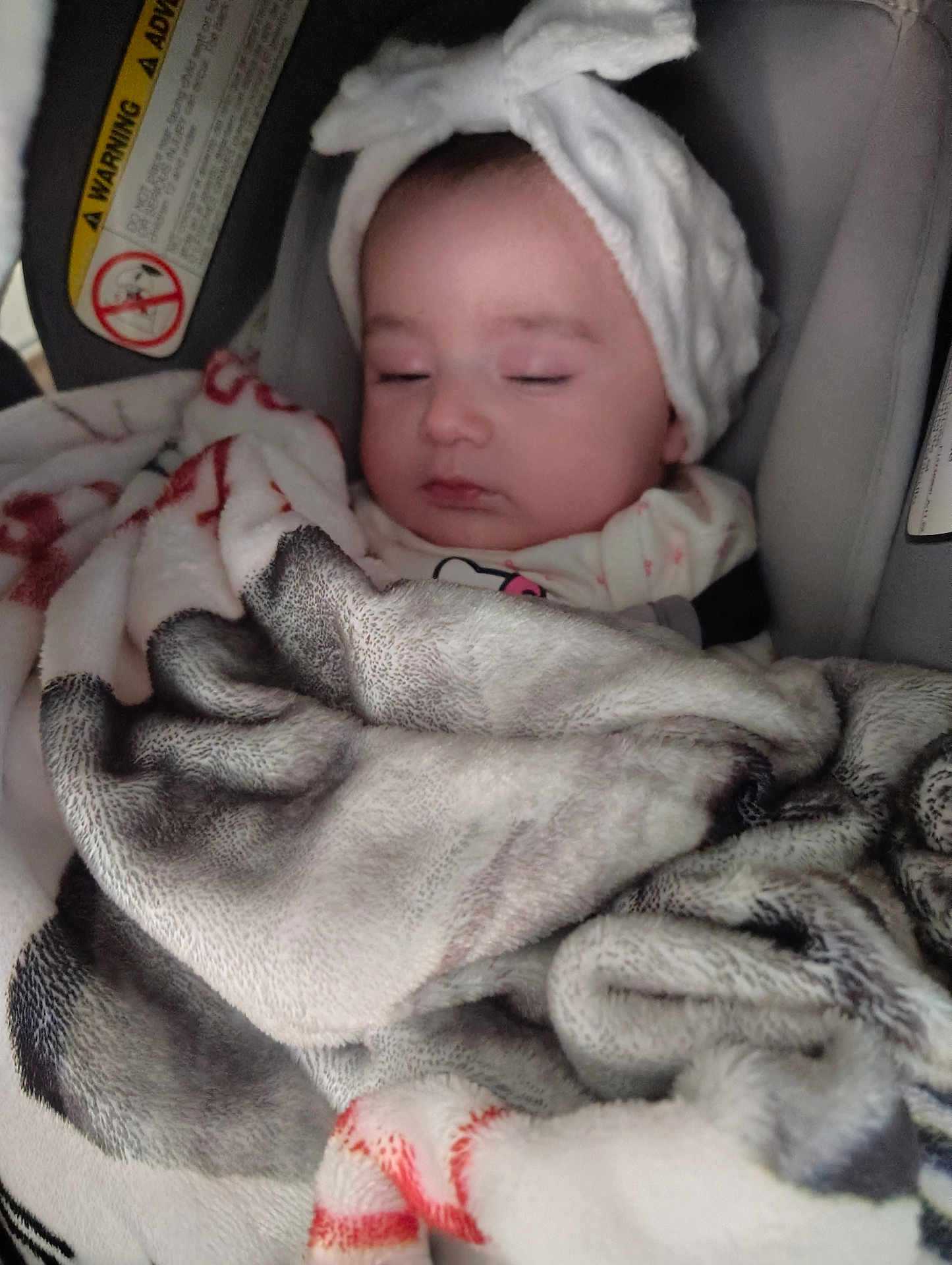 Jaliah is registered to the contest to win money with this photo: baby, sleeping, blanket, headband, car_seat, infant, child, face, closed_eyes, cozy, soft, bow, clothing, warning_label, indoor, portrait, cute, resting, wrapped, comfort