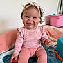 Angelina a rejoint le concours — aidez-le/la à gagner de superbes lots ! baby, child, smiling, pink_clothing, headband, curly_hair, indoor, play_mat, toy, cushion, happy, sitting, infant, person, cute, young_child, joyful, soft_toy, home, portrait