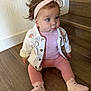 baby, child, indoor, stairs, wooden_floor, pink_clothing, headband, jacket, socks, cute, sitting, portrait, infant, person, face, blue_eyes, curly_hair, expression, floor, casual_wear