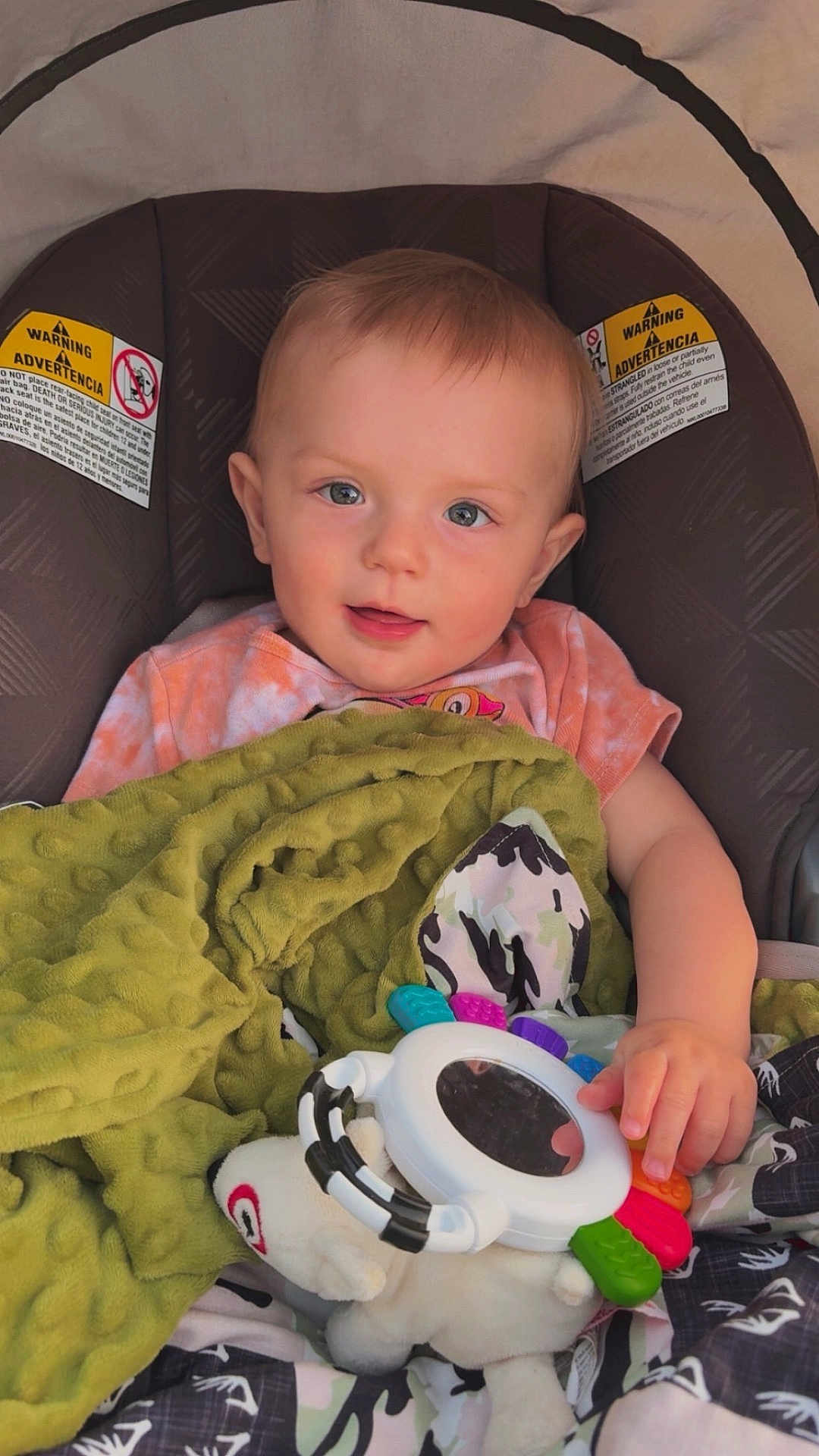Jaxson is registered to the contest to win money with this photo: baby, child, car_seat, blanket, toy, cute, infant, smiling, face, hand, comfort, indoor, clothing, colorful, happy, young, portrait, seat, play, soft
