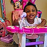 toddler, child, toy_keyboard, microphone, minnie_mouse, pink, purple, playroom, carpet, smiling, waving, indoor, child_toy, cute, happy, person, furniture, colorful, plastic, young_child
