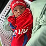 baby, infant, red_blanket, red_hat, basket, white_basket, face, expression, wrapped, soft_fabric, green_fabric, newborn, small, cute, indoors, portrait, clothing, lying_down, young_child, headwear