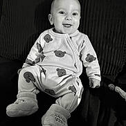 Maylone a rejoint le concours — aidez-le/la à gagner de superbes lots ! baby, smiling, infant, pajamas, bear_pattern, booties, sitting, face, cute, child, cozy, happy, indoors, portrait, black_and_white, soft_texture, clothing, person, comfortable, joyful