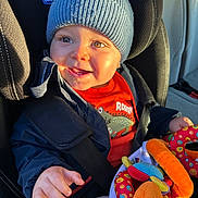 Alessio a rejoint le concours — aidez-le/la à gagner de superbes lots ! toddler, child, car_seat, blue_hat, jacket, plush_toy, colorful_toy, happy, smiling, indoors, seatbelt, clothing, person, face, hand, sunlight, car_interior, window_light, cute, baby