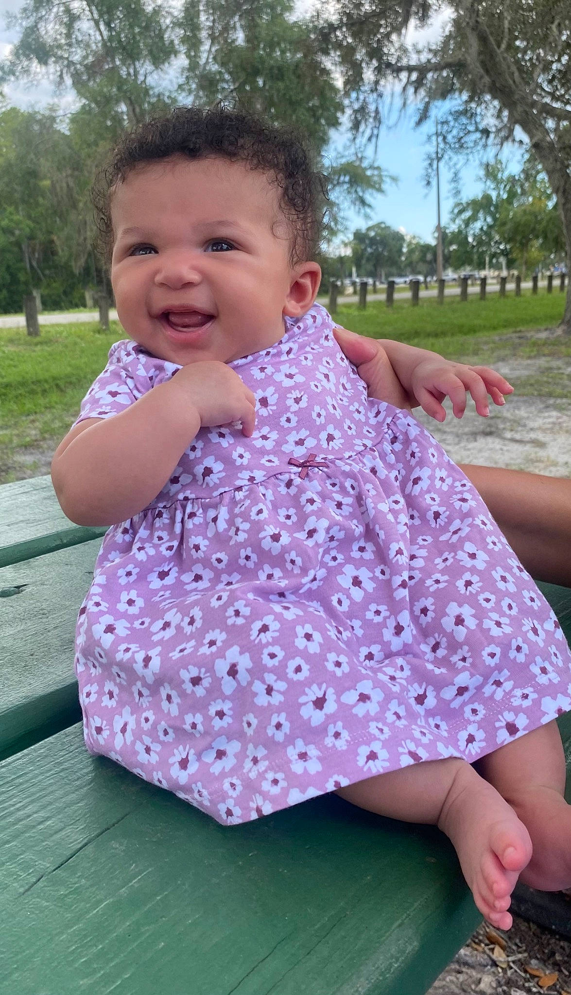 Xaria is registered to the contest to win money with this photo: baby, baby_toddler_clothing, dress, facial_expression, finger, gesture, grass, hairstyle, happy, one_piece_garment, person, photograph, pink, purple, skin, sleeve, smile, summer, toddler, tree