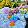 Aiyana is registered to the contest to win money with this photo: baby, blanket, easter_eggs, pink_tutu, headband, outdoor, spring, grass, flower_bed, colorful, infant, cute, portrait, sunlight, nature, child, toy, relaxing, soft_texture, playful