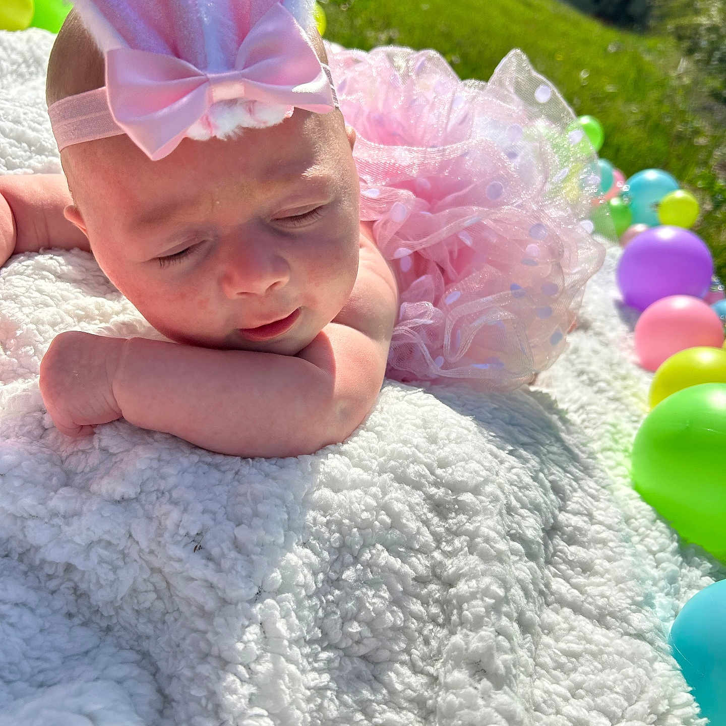 Aiyana is registered to the contest to win money with this photo: baby, bunny_ears, pink_tutu, blanket, balloons, outdoor, grass, sunlight, sleeping, cute, headband, infant, soft_texture, pastel_colors, face, peaceful, child, portrait, toddler, resting