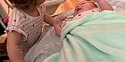 Lillianna joined the competition — help win amazing prizes! baby, child, infant, blanket, curly_hair, indoor, toy, box, floor, bed, holding_hands, toddler, cute, family, soft, playroom, person, clothing, furniture, sleeping