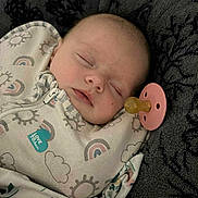Lillianna is registered to the contest to win money with this photo: baby, sleeping, pacifier, blanket, clothing, infant, cozy, face, closed_eyes, soft_texture, patterned, rainbow, cloud, cute, child, portrait, resting, indoors, comfort, peaceful