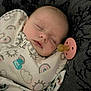 baby, sleeping, pacifier, blanket, clothing, infant, cozy, face, closed_eyes, soft_texture, patterned, rainbow, cloud, cute, child, portrait, resting, indoors, comfort, peaceful