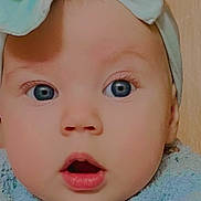 Paige is registered to the contest to win money with this photo: baby, face, closeup, blue_eyes, headwrap, clothing, expression, surprised, cute, infant, child, skin, portrait, young, human, apparel, headwear, indoors, soft_texture, adorable