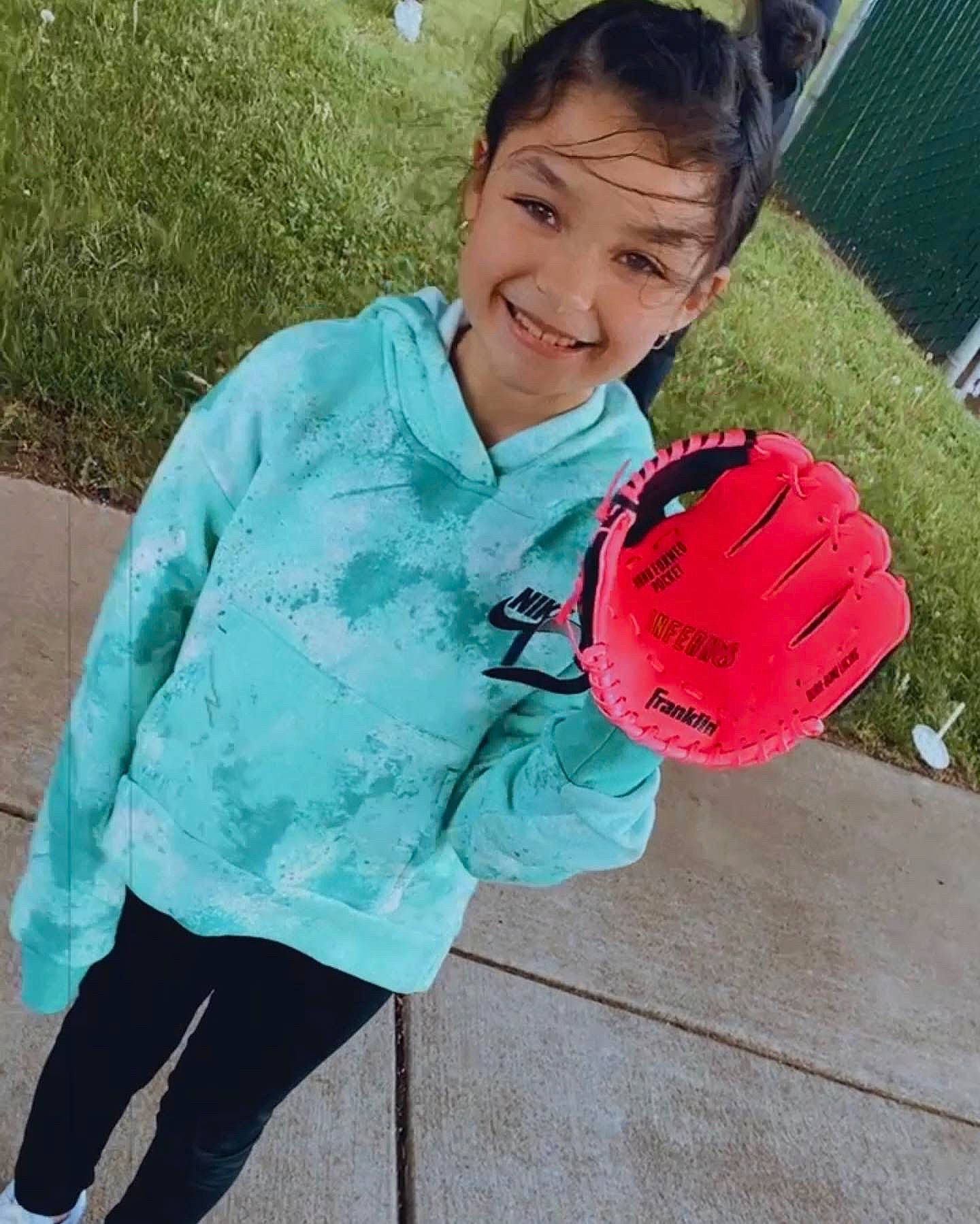 Arianna is registered to the contest to win money with this photo: ball, cap, child, electric_blue, fashion_accessory, football, fun, glove, grass, happy, joy, leisure, person, personal_protective_equipment, play, recreation, smile, sports_equipment, sports_gear, t_shirt