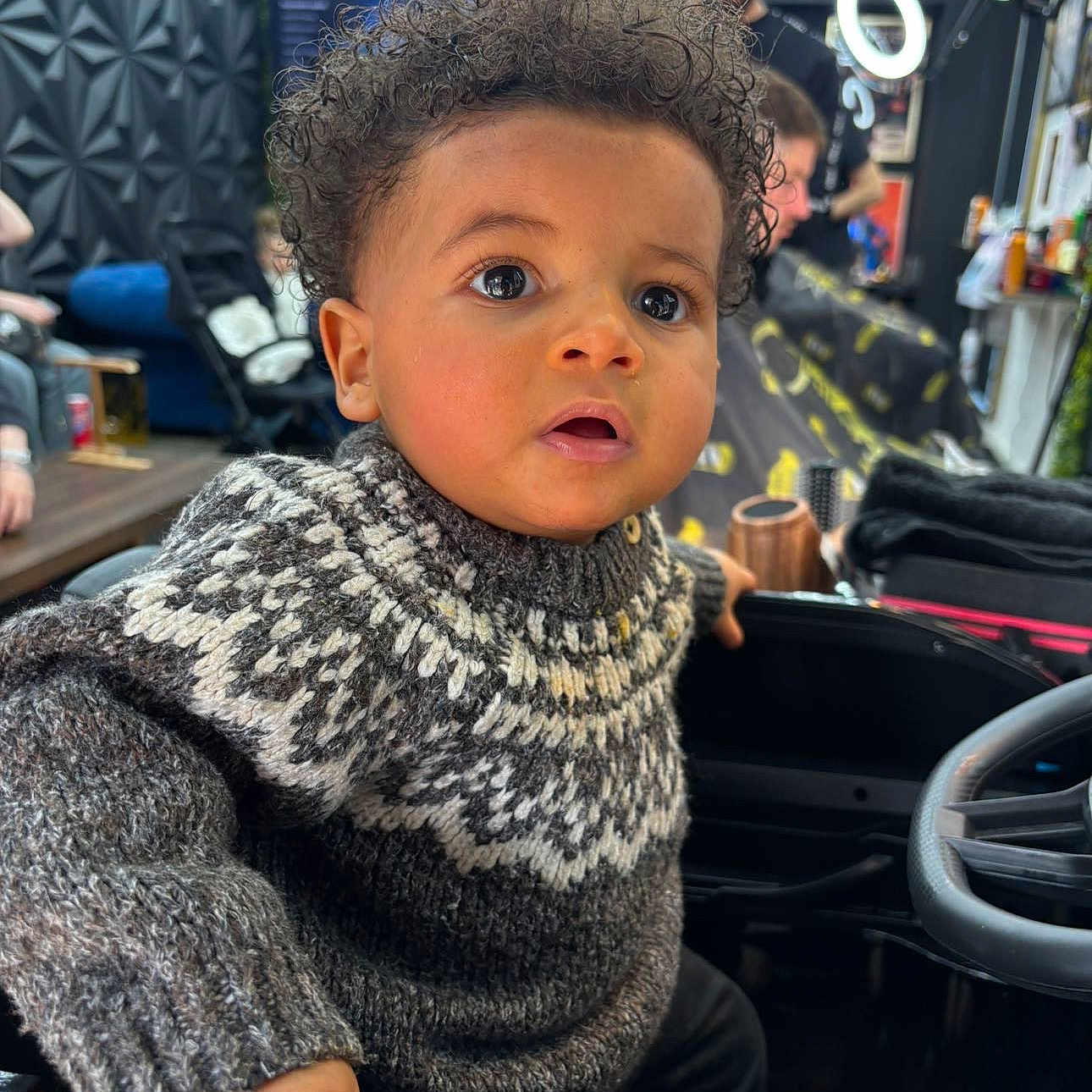 Giovani participe au concours pour gagner de l'argent avec cette photo : adult, baby, blackhair, clothing, curlyhair, face, hair, happy, head, knitwear, male, man, person, photobombing, photography, portrait, smokepipe, sweater, transportation, vehicle