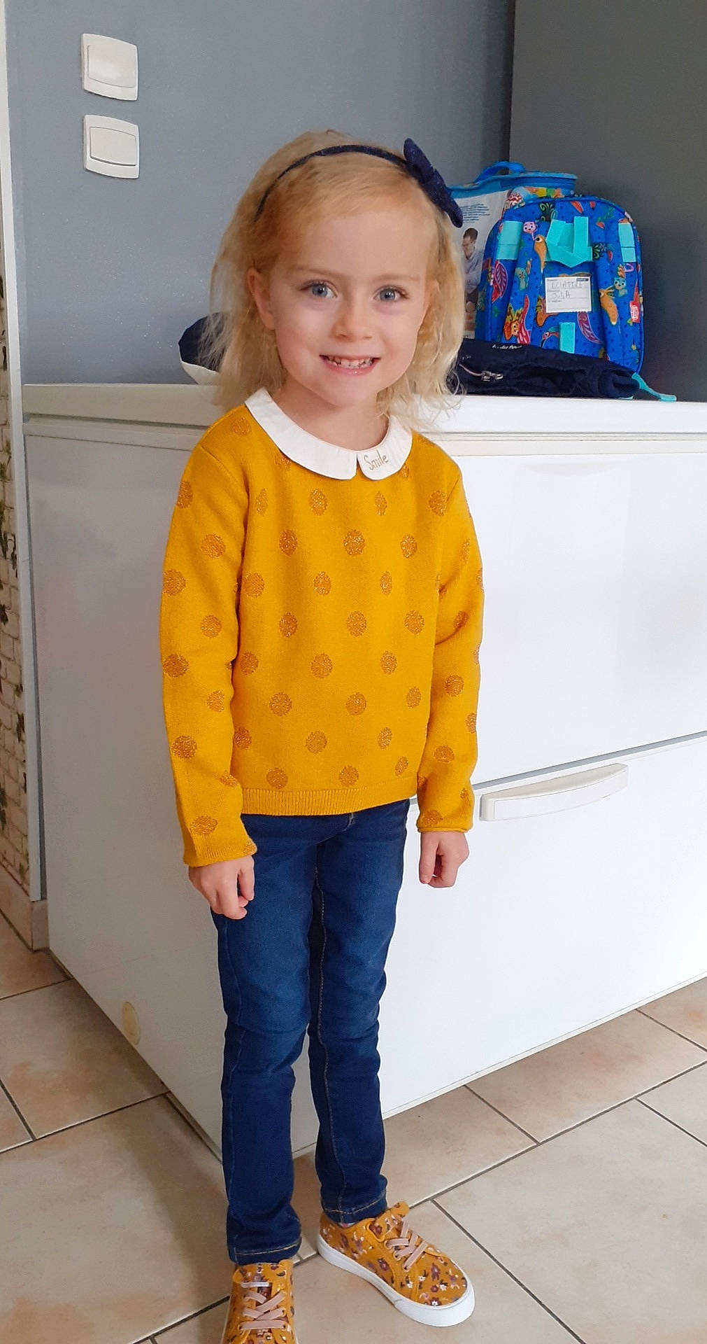 Julia participe au concours pour gagner de l'argent avec cette photo : child, child_model, clothing, footwear, jeans, joy, outerwear, pattern, person, sleeve, standing, sweater, t_shirt, toddler, top, trousers, yellow