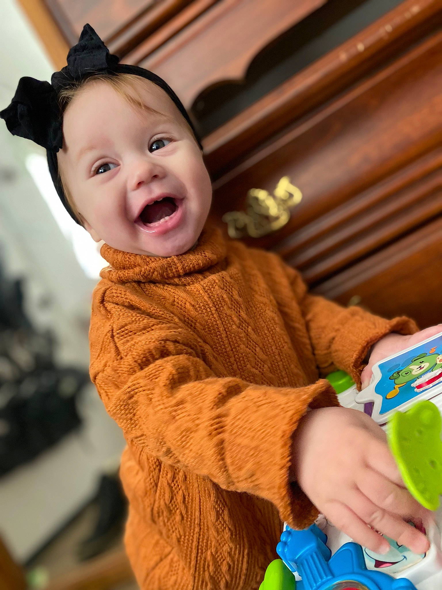 Everleigh is registered to the contest to win money with this photo: baby, child, finger, fun, fur, green, hand, happy, leisure, nail, person, plastic_bottle, product, sitting, sleeve, smile, toddler, wood, wool, woolen
