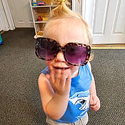 Jadeyn joined the competition — help win amazing prizes! toddler, child, sunglasses, blue_shirt, shorts, barefoot, carpet, indoor, dollhouse, toy, door, hair_tied, smiling, person, young_child, cute, casual_clothing, playful, portrait, fun