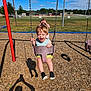 Jadeyn joined the competition — help win amazing prizes! child, toddler, swing, playground, wood_chips, grass, sky, clouds, trees, fence, chain, sports_field, daylight, fun, happy, smile, casual_clothing, outdoor, recreation, shadow