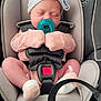 newborn, baby, car_seat, pacifier, pink_clothing, striped_hat, bow, sleeping, infant, safety_harness, closeup, child, cute, indoors, soft_lighting, sock, seatbelt, resting, adorable, transportation