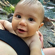 Finan is registered to the contest to win money with this photo: baby, child, face, eyes, smile, skin, arm, person, outdoor, nature, rock, water, stream, hand, holding, closeup, young, curious, innocent, light