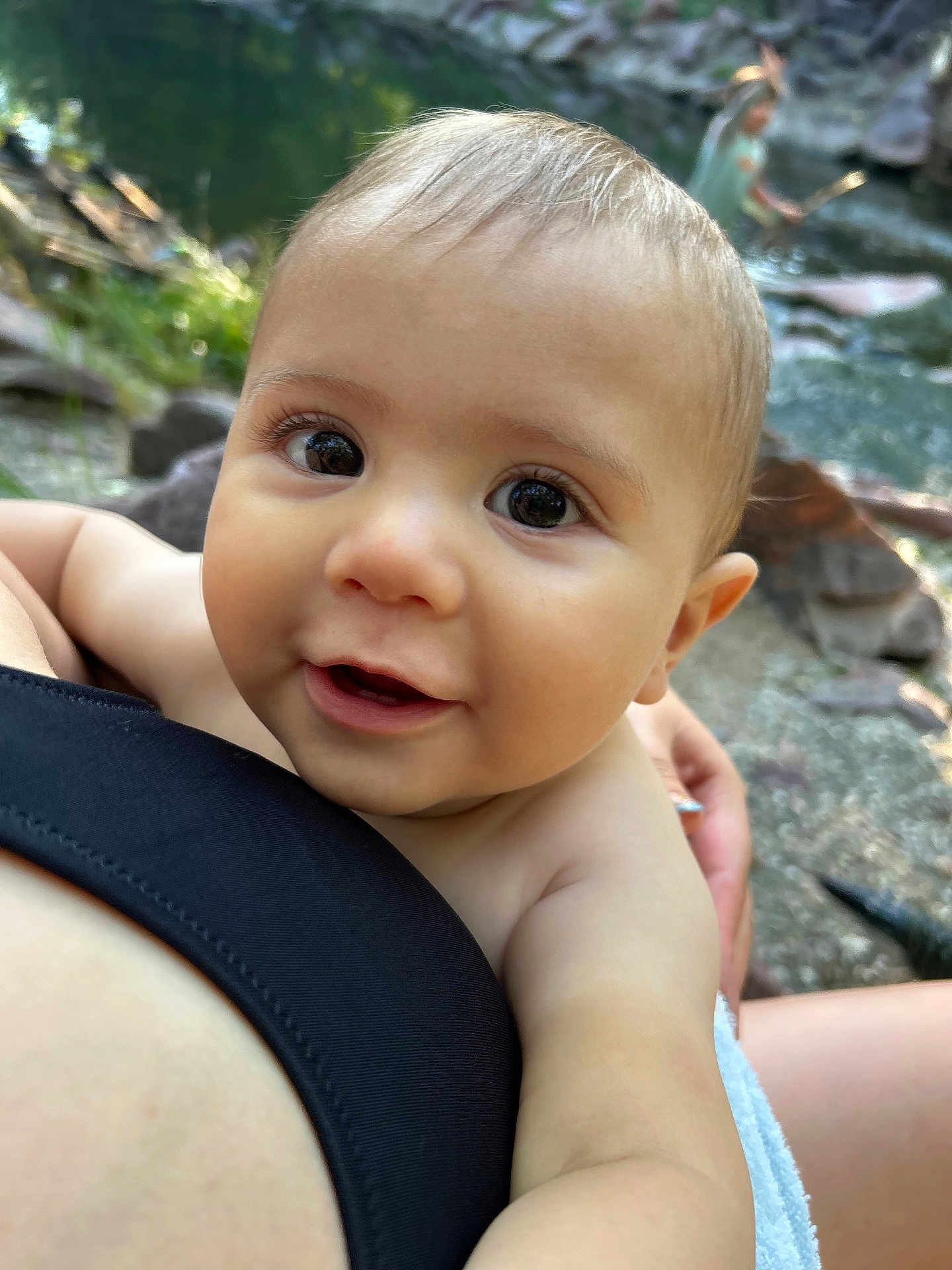 Finan is registered to the contest to win money with this photo: baby, child, face, eyes, smile, skin, arm, person, outdoor, nature, rock, water, stream, hand, holding, closeup, young, curious, innocent, light