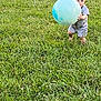 toddler, child, ball, grass, outdoor, playing, toy, field, greenery, casual_clothing, summer, daylight, person, young_child, nature, fun, activity, cute, holding, barefoot