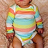 baby, infant, onesie, striped_clothing, colorful, blanket, soft_texture, cute, portrait, child, sitting, indoors, human, newborn, small, skin, face, legs, hands, expression