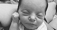 Kinsley is registered to the contest to win money with this photo: baby, newborn, sleeping, infant, person, closeup, black_and_white, cute, peaceful, hand, face, clothing, soft, resting, portrait, human, tender, lap, onesie, quiet