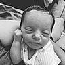 baby, newborn, sleeping, infant, person, closeup, black_and_white, cute, peaceful, hand, face, clothing, soft, resting, portrait, human, tender, lap, onesie, quiet