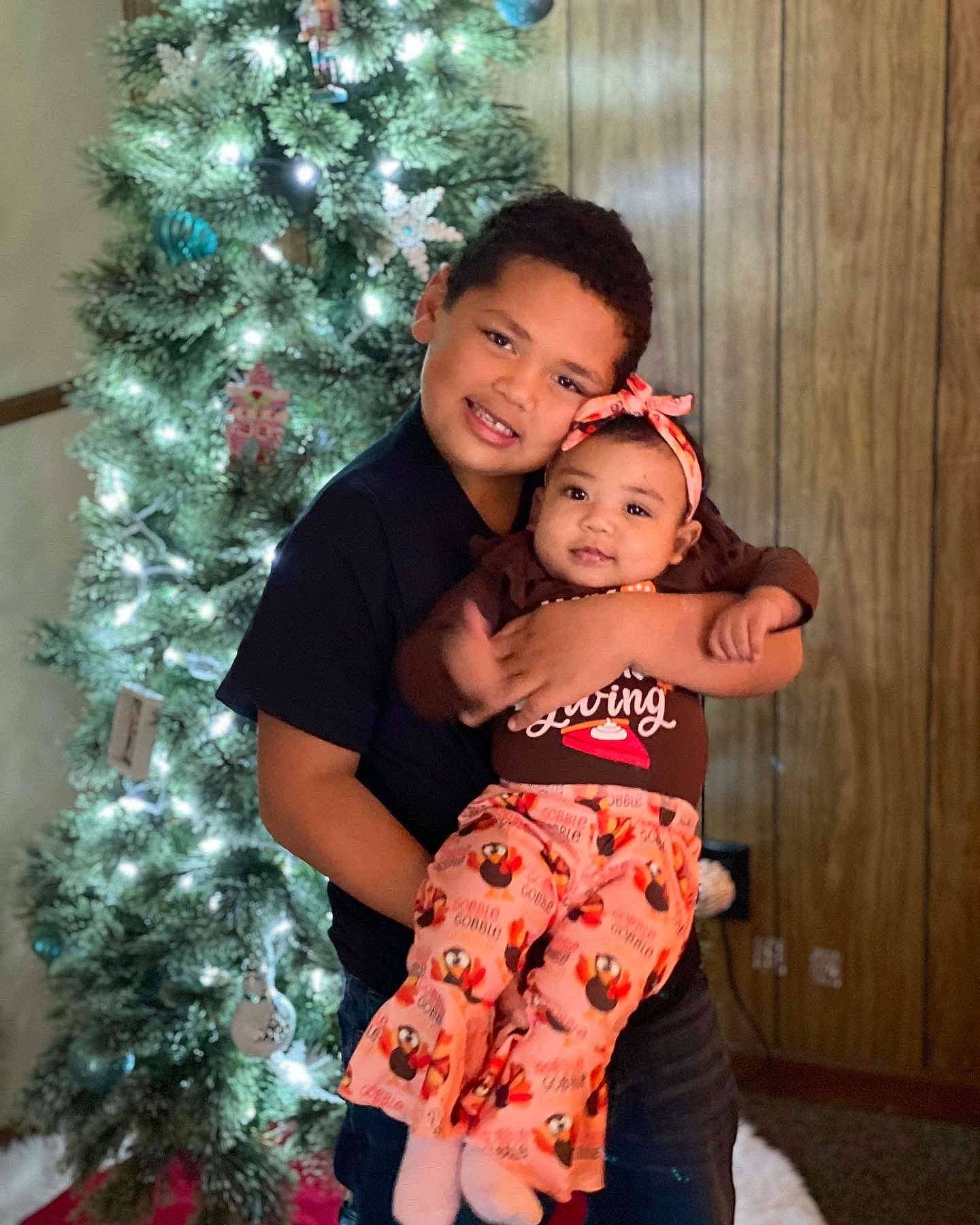 Aniya is registered to the contest to win money with this photo: baby_toddler_clothing, christmas_decoration, christmas_ornament, christmas_tree, event, evergreen, flash_photography, fun, green, happy, head, holiday, holiday_ornament, joy, ornament, person, red, sleeve, smile, standing