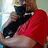 affection, animal, cat, cozy, curtains, cute, feline, glasses, holding, indoor, kitten, light, man, person, pet, portrait, red_shirt, smile, tattoo, window