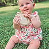baby, child, cute, dress, flower_pattern, grass, greenery, happy, headband, holding, infant, nature, outdoor, plaque, portrait, sitting, smiling, summer, sunlight, young