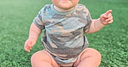 Bexley joined the competition — help win amazing prizes! baby, camouflage, child, curious, cute, daylight, face, grass, green, headband, infant, nature, onesie, outdoor, people, playful, portrait, sitting, toes, young