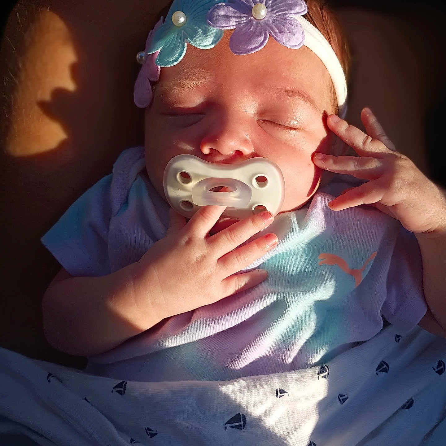Rythym joined the competition — help win amazing prizes! baby, blanket, blue, close_up, clothing, cozy, face, flowers, hands, headband, indoors, infant, newborn, pacifier, peaceful, photography, portrait, purple, sleeping, sunlight