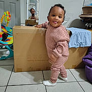 Tayzon is registered to the contest to win money with this photo: toddler, child, indoor, cardboard_box, mirror, woman, phone, floor_tiles, baby_rocker, clothing, socks, playful, tongue_out, furniture, window_blinds, bean_bag, home, person, reflection, casual