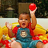 Giovanni joined the competition — help win amazing prizes! baby, child, ball_pit, colorful_balls, denim_overalls, monkey_patch, red_ball, happy, playful, outdoor, smiling, barefoot, short_sleeve_shirt, cute, infant, portrait, fun, expression, toys, summer