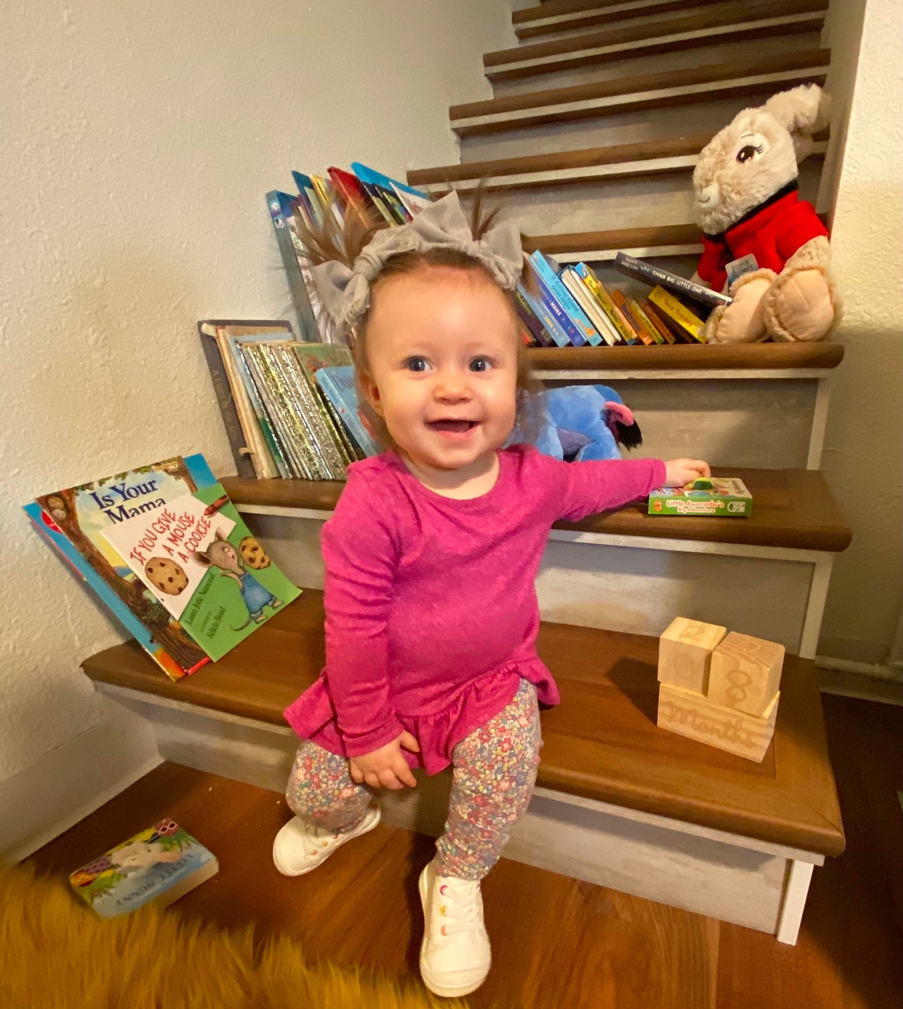 Harper joined the competition — help win amazing prizes! baby_toddler_clothing, book, bookcase, chair, child, drawer, floor, flooring, happy, hardwood, house, human_body, joy, person, pink, shelf, shelving, sleeve, smile, t_shirt