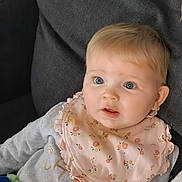 Sophie participe au concours pour gagner de l'argent avec cette photo : baby, child, infant, blue_eyes, bib, clothing, couch, face, floral, furniture, indoors, person, portrait, sitting, soft, toy, young, cute, expression, light